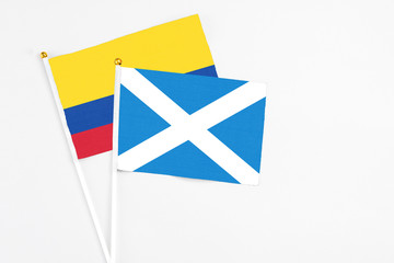 Scotland and Colombia stick flags on white background. High quality fabric, miniature national flag. Peaceful global concept.White floor for copy space.