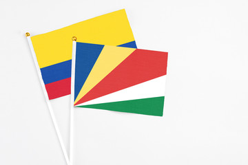 Seychelles and Colombia stick flags on white background. High quality fabric, miniature national flag. Peaceful global concept.White floor for copy space.