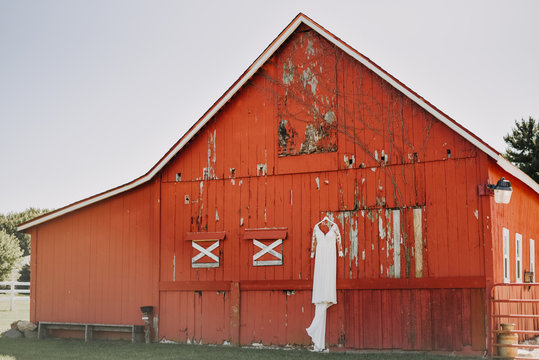 red barn with white wedding dress hanging from it