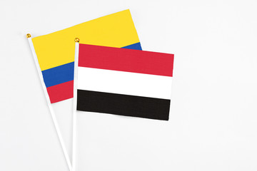 Yemen and Colombia stick flags on white background. High quality fabric, miniature national flag. Peaceful global concept.White floor for copy space.