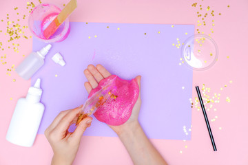 How to make slime at home. Children art project. DIY concept. Kids hands making slime toy on pink. Step by step photo instruction. Step 10