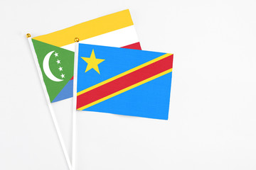 Congo and Comoros stick flags on white background. High quality fabric, miniature national flag. Peaceful global concept.White floor for copy space.