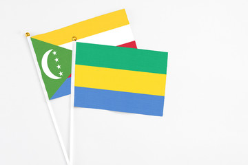 Gabon and Comoros stick flags on white background. High quality fabric, miniature national flag....