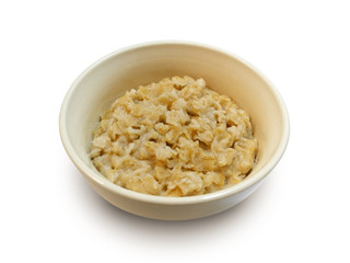 Oatmeal porridge in white earthenware bowl isolated on white background side view 