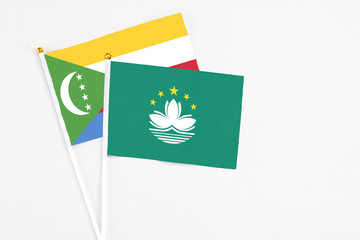 Macao and Comoros stick flags on white background. High quality fabric, miniature national flag. Peaceful global concept.White floor for copy space.
