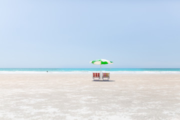 Two beach chairs and an umbrella on an empty Cable Beach in Broome, Western Australia