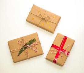 Holiday gift boxes decorated with ribbons and pine on white background.