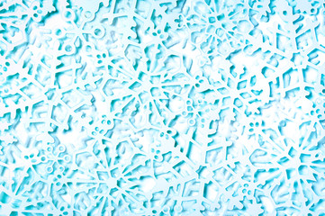Full frame wintry background of textured glittery blue snowflakes