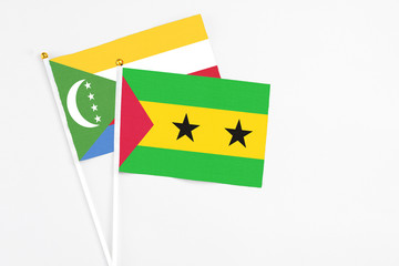 Sao Tome And Principe and Comoros stick flags on white background. High quality fabric, miniature national flag. Peaceful global concept.White floor for copy space.