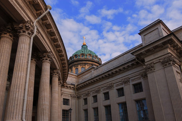 Fototapeta na wymiar A fragment of the Kazan Cathedral. St. Petersburg. Russia. Part of the colonnade and the dome are visible. Blue sky with clouds. Background. Scenery. Details