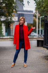 Girl in fashionable girl red warm coat  Attractive blonde city knitted sweater spring autumn collection
