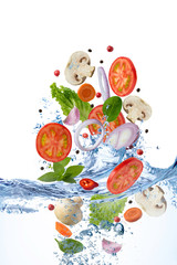 Flying tomato,   champignons and  spices under running water on the white background. Selective focus.