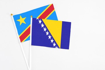 Bosnia Herzegovina and Congo stick flags on white background. High quality fabric, miniature national flag. Peaceful global concept.White floor for copy space.