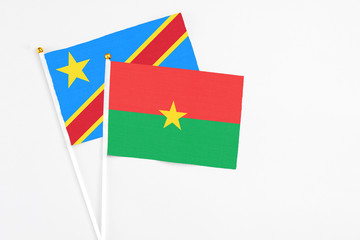 Burkina Faso and Congo stick flags on white background. High quality fabric, miniature national flag. Peaceful global concept.White floor for copy space.