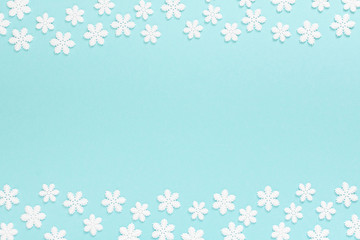 Holiday pastel background, white snowflakes on a gentle blue background ,flat lay, top view
