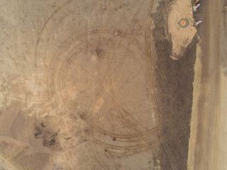 Aerial view on a construction site; pile of pebble; Heavy machinery tracks on the ground. Nobody.