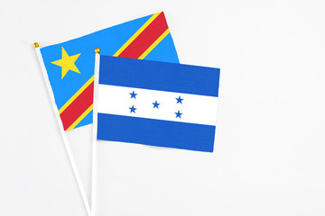 Honduras and Congo stick flags on white background. High quality fabric, miniature national flag. Peaceful global concept.White floor for copy space.