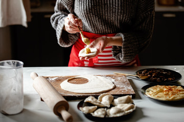 Fototapeta na wymiar woman cooking polish dumplings at kitchen