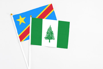 Norfolk Island and Congo stick flags on white background. High quality fabric, miniature national flag. Peaceful global concept.White floor for copy space.