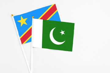 Pakistan and Congo stick flags on white background. High quality fabric, miniature national flag. Peaceful global concept.White floor for copy space.