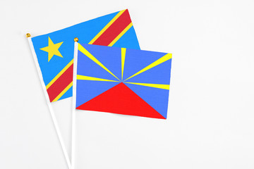Reunion and Congo stick flags on white background. High quality fabric, miniature national flag. Peaceful global concept.White floor for copy space.
