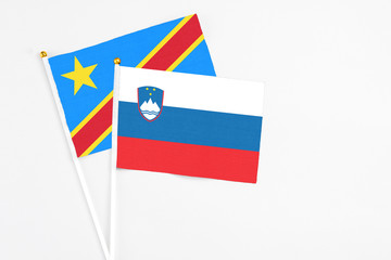 Slovenia and Congo stick flags on white background. High quality fabric, miniature national flag. Peaceful global concept.White floor for copy space.