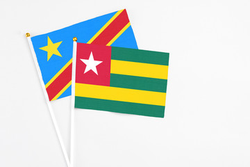 Togo and Congo stick flags on white background. High quality fabric, miniature national flag. Peaceful global concept.White floor for copy space.