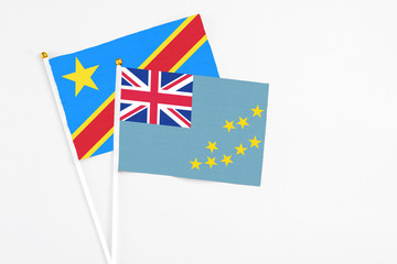 Fototapeta premium Tuvalu and Congo stick flags on white background. High quality fabric, miniature national flag. Peaceful global concept.White floor for copy space.