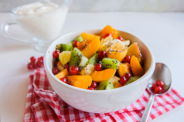 A bowl of fresh berry fruit salad on the white kitchen table. Vegan snack, diet food, healthy food concept.