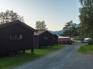 Fototapeta na wymiar View of Classical Norwegian Camping site Bravoll with traditional wooden cottages cabins at Kinsarvik by the Sorfjorden branch of Hardanger Fjord in Kinsarvik, Norway