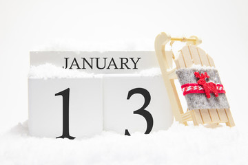 Wooden calendar for January, 13 th day of the winter month. The symbols of winter are snow and...