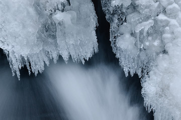 Frozen winter figures in the mountain winter river