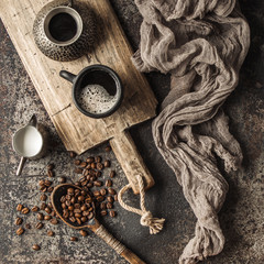 Coffee on wooden board with coffee beans on dark textured background. Top view with copy space. Background with free text space.