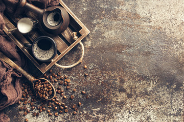 Fototapeta na wymiar Coffee on wooden tray with coffee beans on dark textured background. Top view with copy space. Background with free text space.