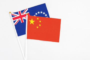 China and Cook Islands stick flags on white background. High quality fabric, miniature national flag. Peaceful global concept.White floor for copy space.