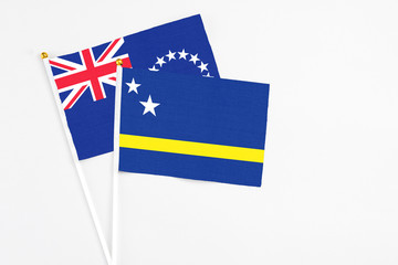 Curacao and Cook Islands stick flags on white background. High quality fabric, miniature national flag. Peaceful global concept.White floor for copy space.