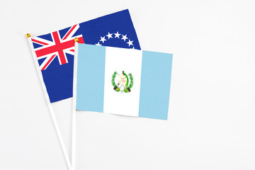Guatemala and Cook Islands stick flags on white background. High quality fabric, miniature national flag. Peaceful global concept.White floor for copy space.