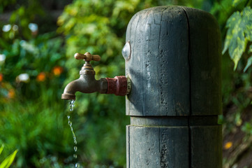 llave de agua abierta mientras cae un chorro de agua. Dia mundial del agua