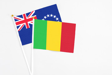 Mali and Cook Islands stick flags on white background. High quality fabric, miniature national flag. Peaceful global concept.White floor for copy space.