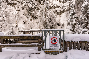 No entry, Power station - warning sign hung on a metal gate. Snow-covered trees and a wooden fence...