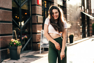 Beautiful smiling woman walking in the city on summer day.