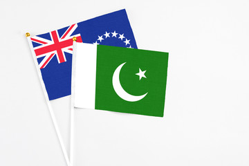 Pakistan and Cook Islands stick flags on white background. High quality fabric, miniature national flag. Peaceful global concept.White floor for copy space.