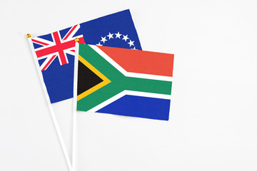 South Africa and Cook Islands stick flags on white background. High quality fabric, miniature national flag. Peaceful global concept.White floor for copy space.