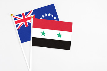 Fototapeta premium Syria and Cook Islands stick flags on white background. High quality fabric, miniature national flag. Peaceful global concept.White floor for copy space.