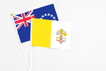 Vatican City and Cook Islands stick flags on white background. High quality fabric, miniature national flag. Peaceful global concept.White floor for copy space.