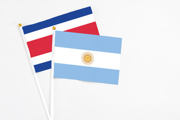 Argentina and Costa Rica stick flags on white background. High quality fabric, miniature national flag. Peaceful global concept.White floor for copy space.