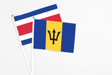 Barbados and Costa Rica stick flags on white background. High quality fabric, miniature national flag. Peaceful global concept.White floor for copy space.