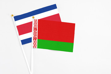 Belarus and Costa Rica stick flags on white background. High quality fabric, miniature national flag. Peaceful global concept.White floor for copy space.