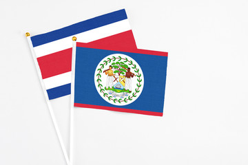 Belize and Costa Rica stick flags on white background. High quality fabric, miniature national flag. Peaceful global concept.White floor for copy space.
