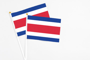 Costa Rica and Costa Rica stick flags on white background. High quality fabric, miniature national flag. Peaceful global concept.White floor for copy space.